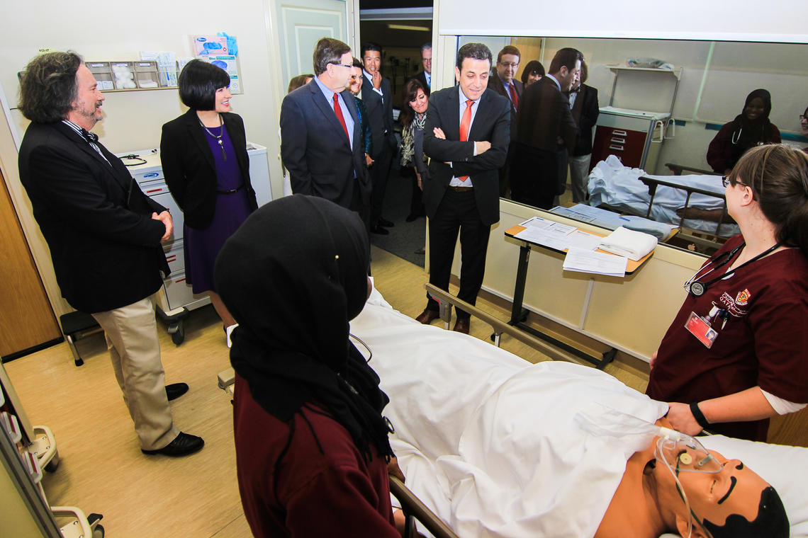 The four parliamentarians chat with students as they work with a simulation mannequin in UCQ's simulation centre