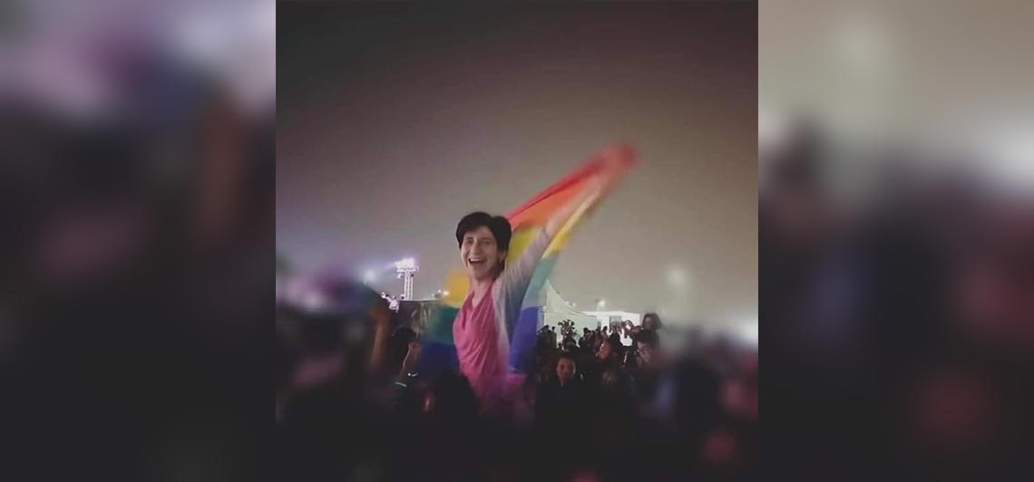 arah Hegazi raises the rainbow flag at a concert in Cairo in 2017. 