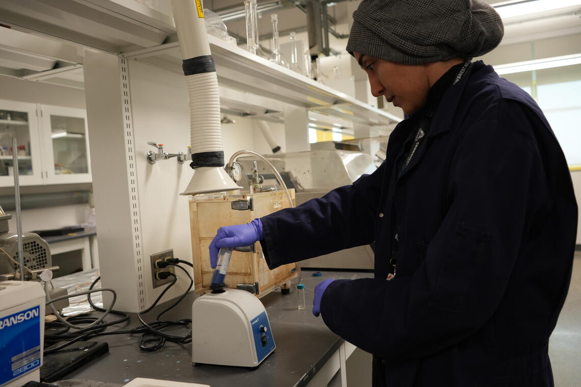 PhD student, Noora Darwish, mixing the biocide with paint.