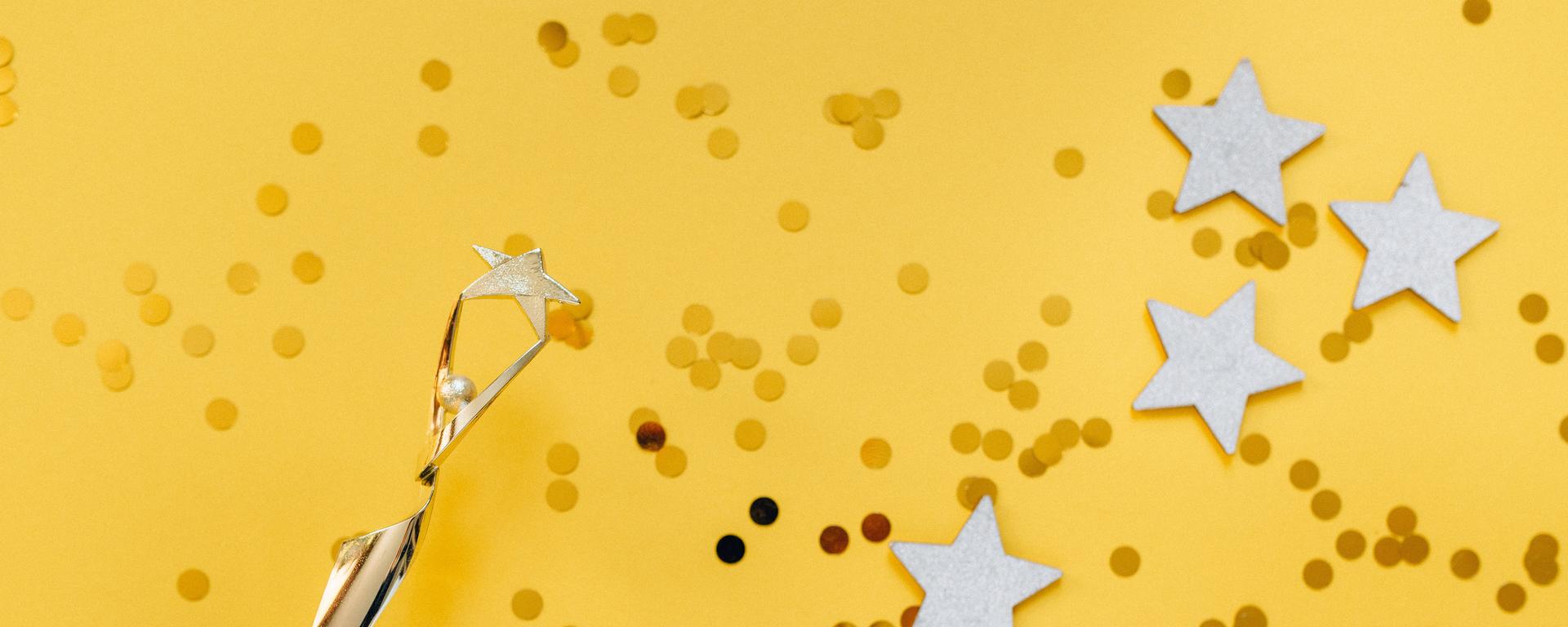 Glitter and stars with trophy on yellow background
