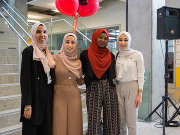 Students pose for candid shots and mingle with each other before heading to the Jack Simpson gym for the convocation ceremony.