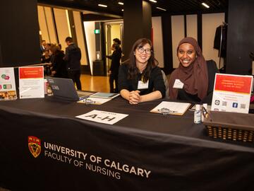 Staff and alumni at registration table for Pinning Ceremony event.