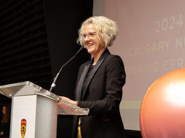 Dean of Faculty of Nursing at podium speaking at Pinning Ceremony. 