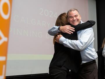 Woman and man hug on stage