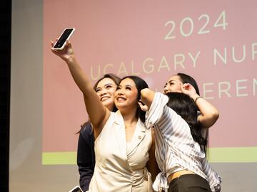 Students post for a selfie on stage at Pinning Ceremony