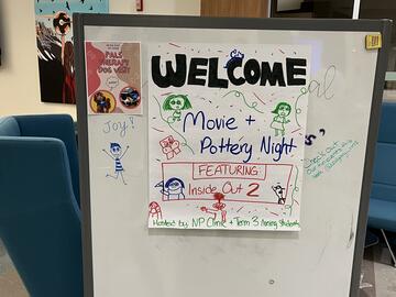 hand made sign describing the Movie event night with cartoon characters drawn on it