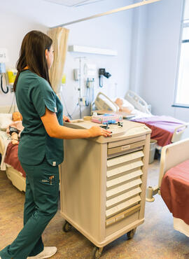 Nurse in srubs at medication cart