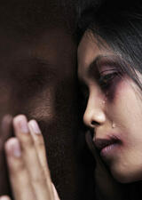 Woman leaning on window, hand on window