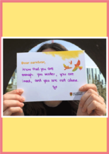 Image of woman holding up an index card with purple writing and birds drawn on it